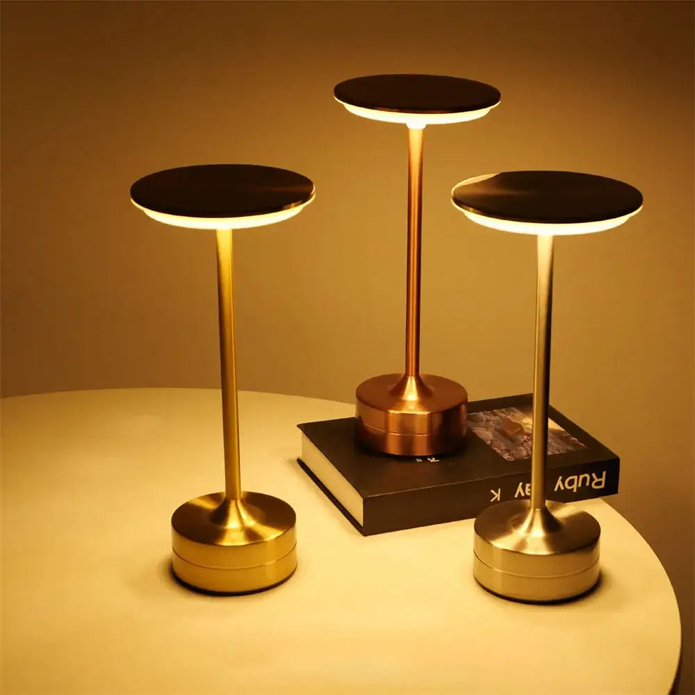 Three elegant gold-toned decorbites simple charging led desk lamps with sleek designs and warm glow for restaurant bar use