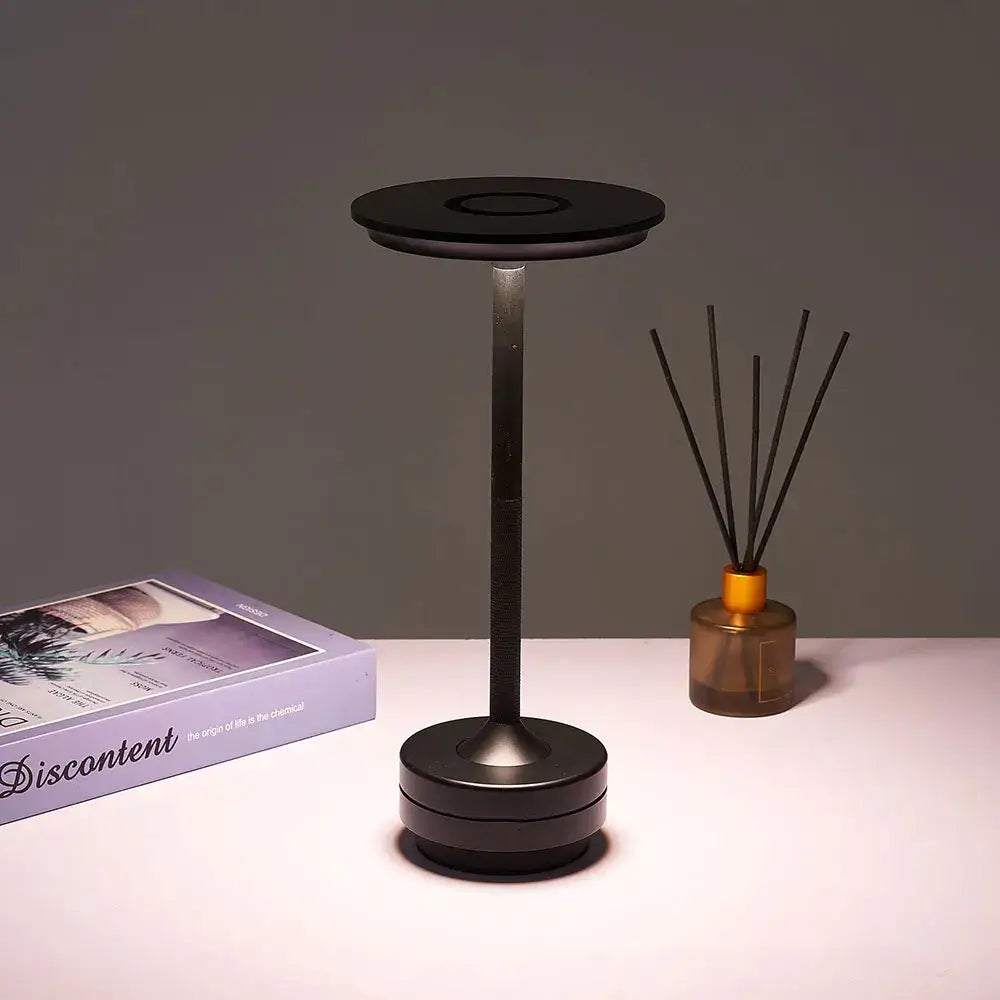 Black minimalist DecorBites™ simple charging LED desk lamp with cylindrical stem and circular base for office use