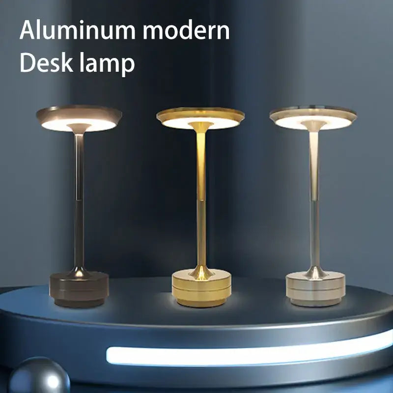 Three sleek aluminum desk lamps in bronze gold and silver with simple charging led and minimalist circular shades