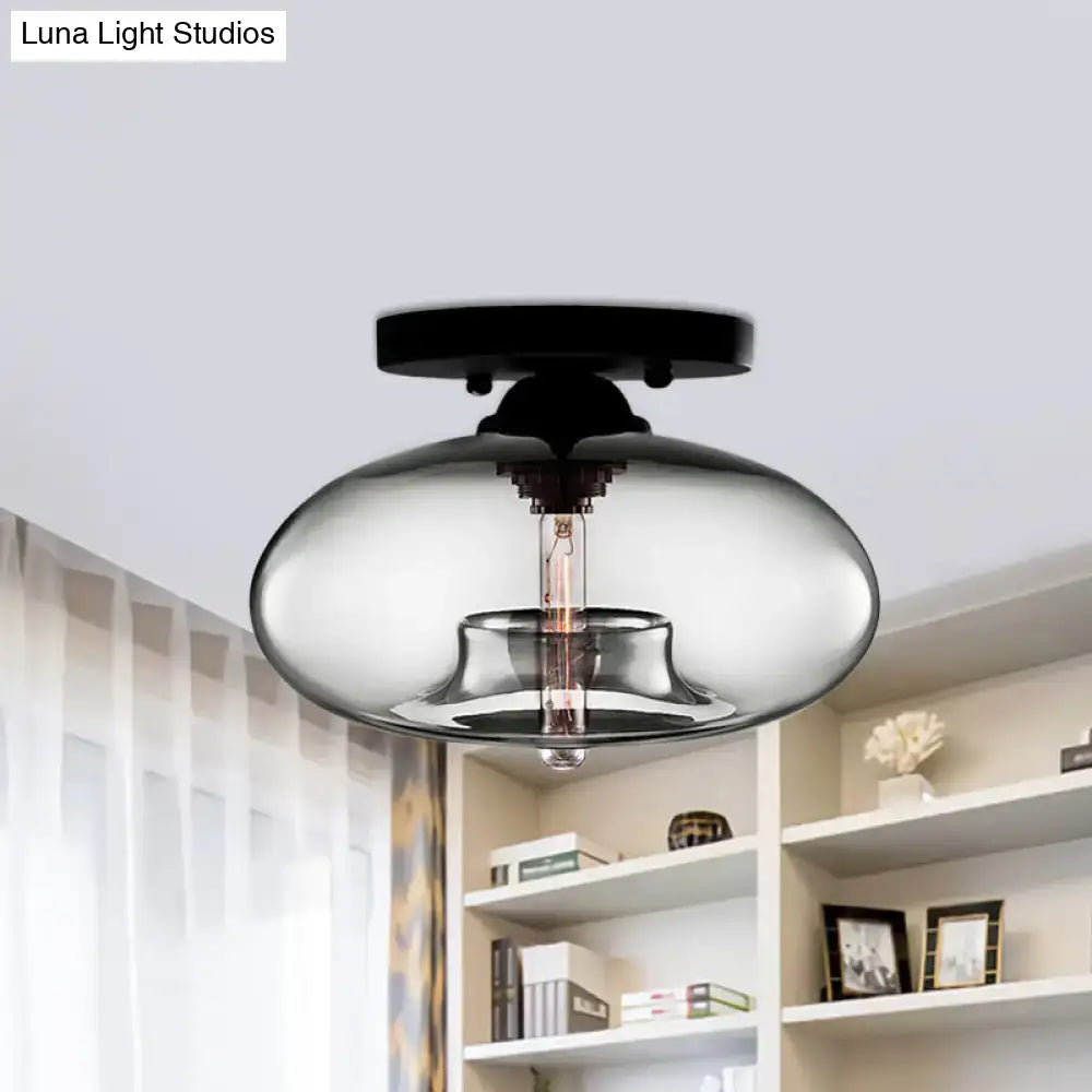 Modern black finished flush mount ceiling light with oval glass smoked shade and exposed filament bulb for hallway use