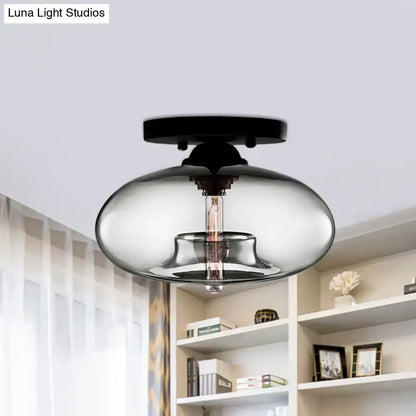 Modern black finished flush mount ceiling light with oval glass smoked shade and exposed filament bulb for hallway use