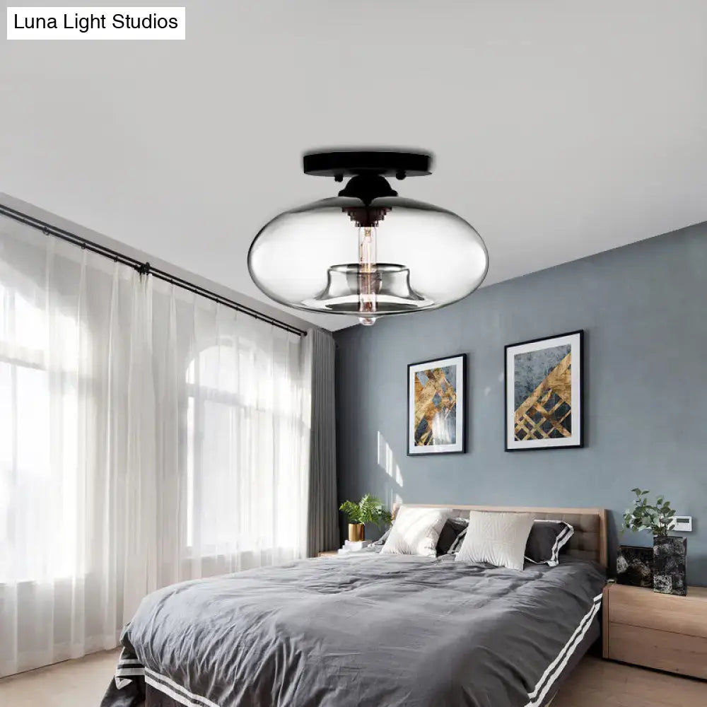 Modern black and clear glass oval flush mount ceiling light fixture with sleek rounded design for hallway use