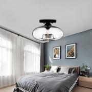 Modern black and clear glass oval flush mount light fixture with sleek rounded design for hallway lighting
