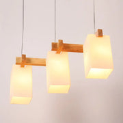 Minimalist DecorBites wood pendant light with three warm-toned opaline glass shades and adjustable chain cord length