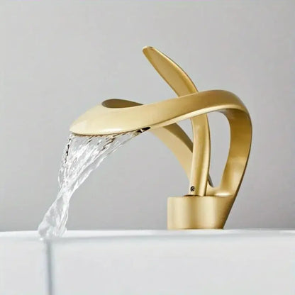 Gold-colored single handle bathroom sink faucet with sleek curved waterfall design for modern bathroom sink use