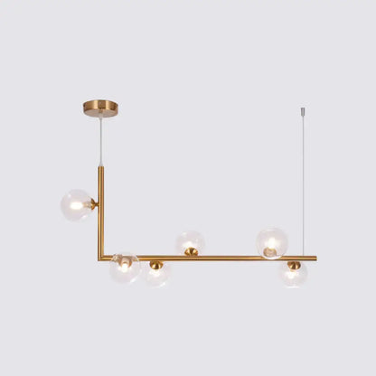Modern gold-toned linear pendant light with clear glass globe bulbs for dining room hanging island by DecorBites