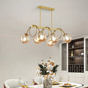 DecorBites sleek gold spiral island light with five glass bulbs on curved metal arms in a gold finish