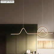 DecorBites sleek island light fixture in black gold metal with minimalistic curves and glowing LED strip lighting
