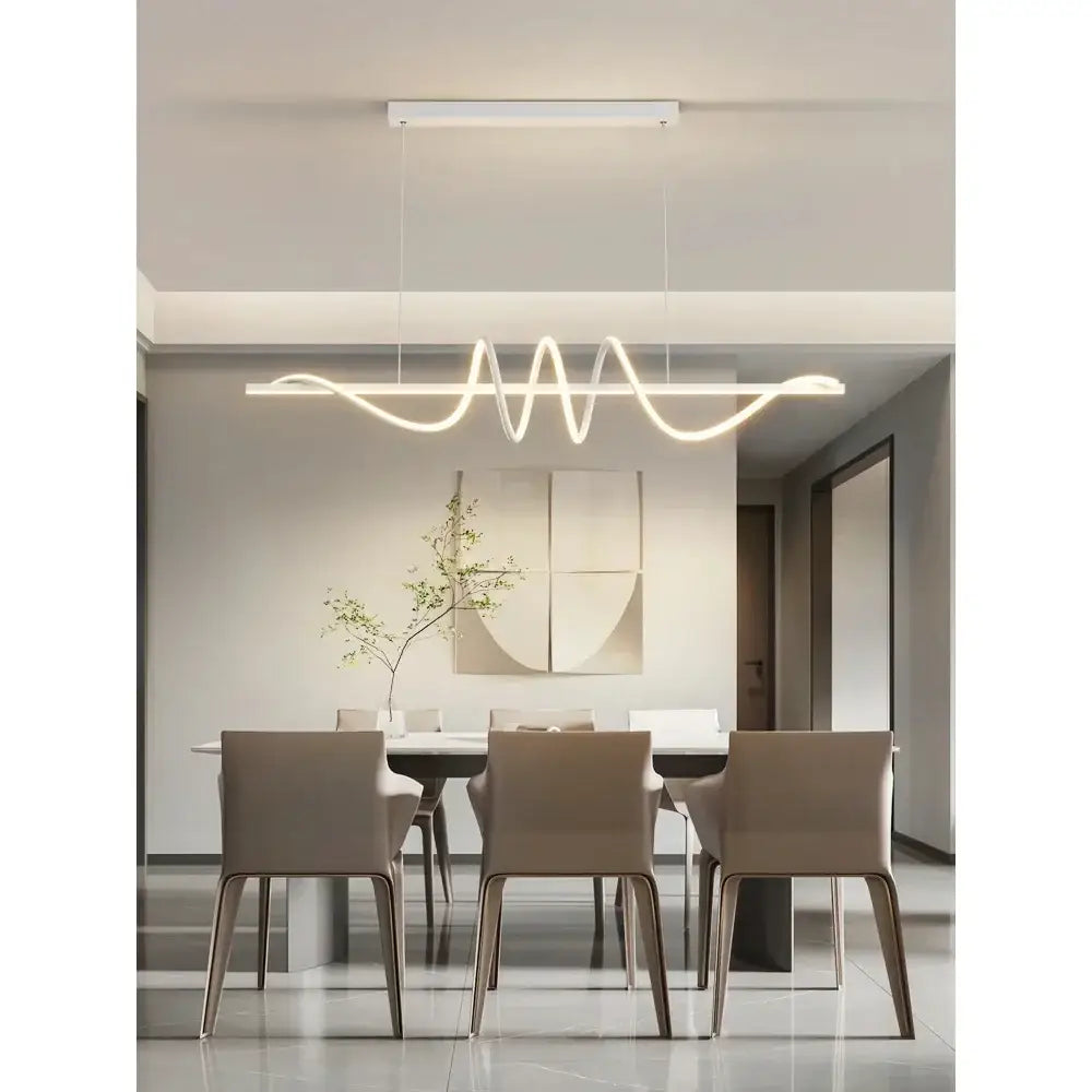 Modern white DecorBites™ sleek wavy pendant lights with LED design hanging above dining room table