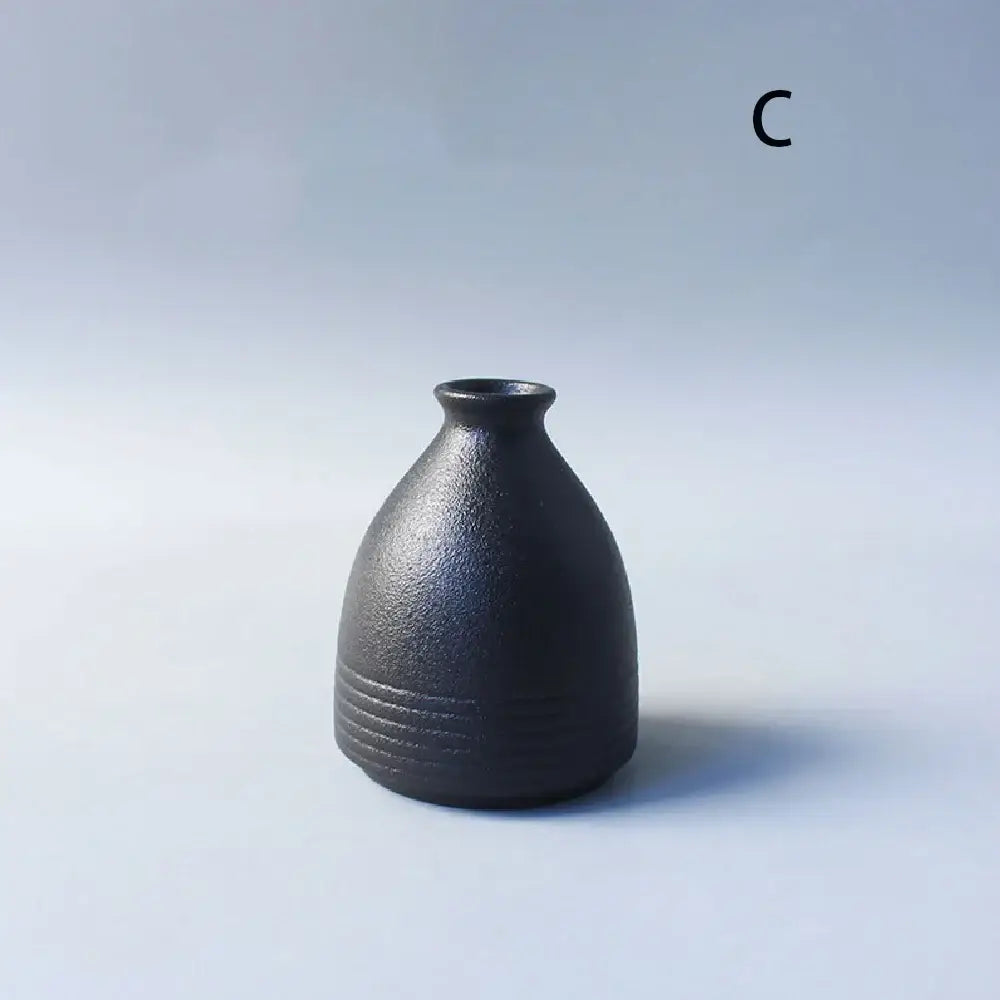 Matte black ceramic small vase with textured surface and subtle ridges for elegant japanese home decor by decorbites