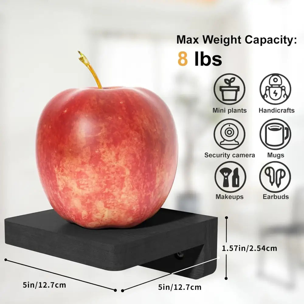 A vibrant red apple with a golden stem on a sleek black decorbites™ 4-pack small floating wood shelves platform