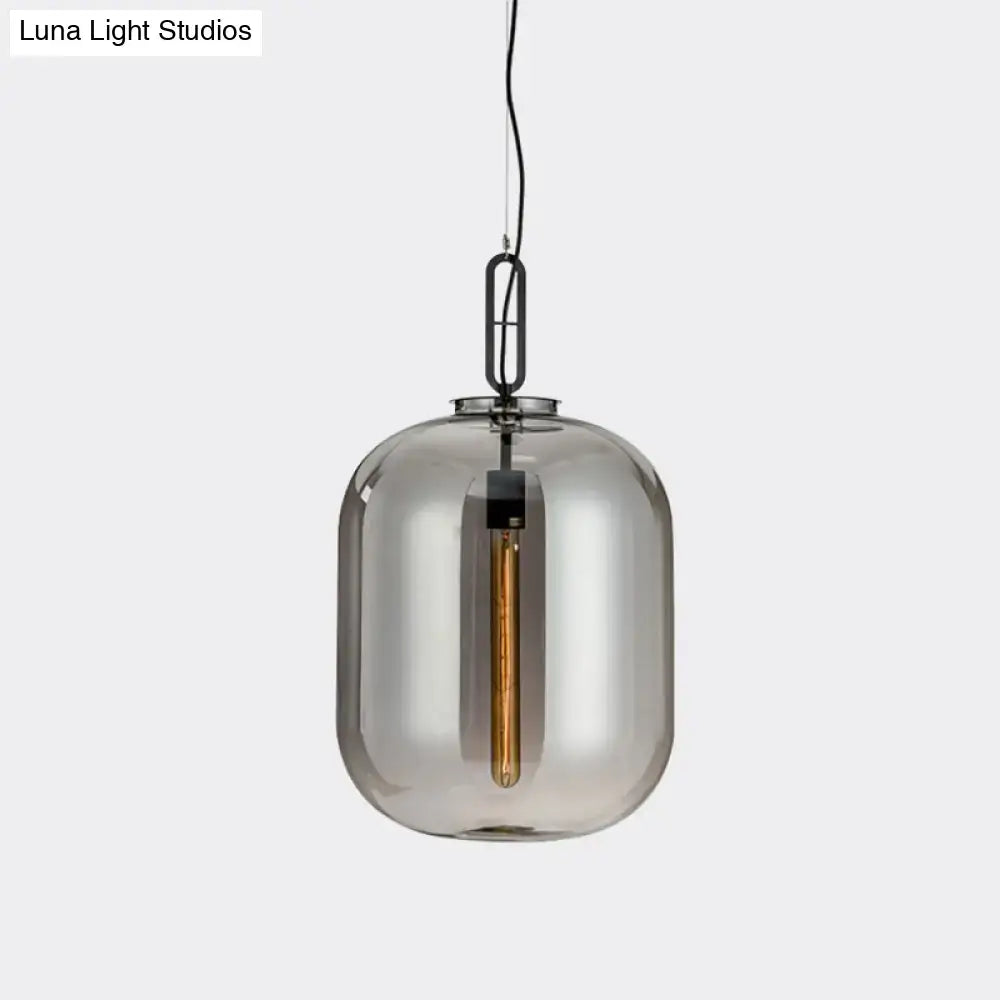 A decorbites smoke gray cognac glass pendant lamp featuring a sleek smoked glass shade with black metal chain