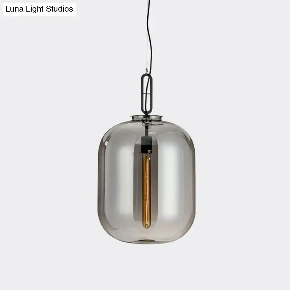 A sleek decorbites smoke gray cognac glass pendant lamp with black metal chain and exposed filament bulb