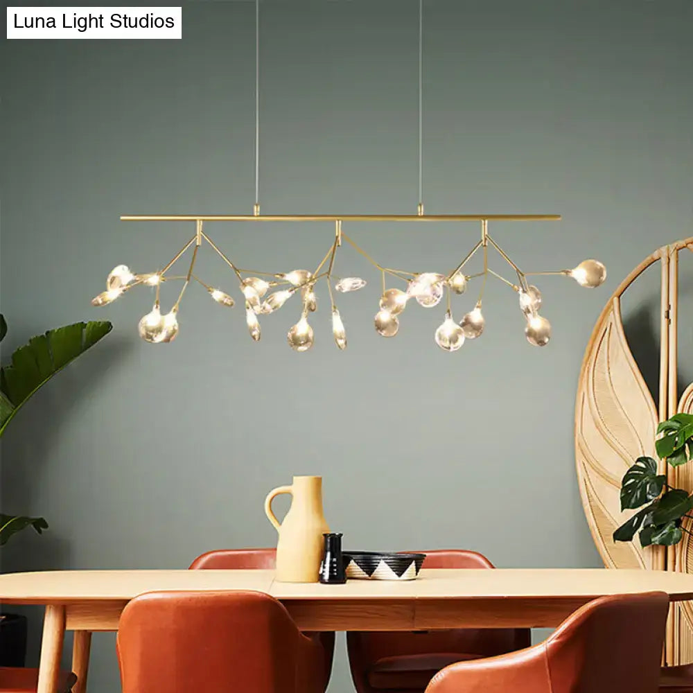 Modern brass pendant light with branching arms and grey glass firefly globes for dining room island lighting