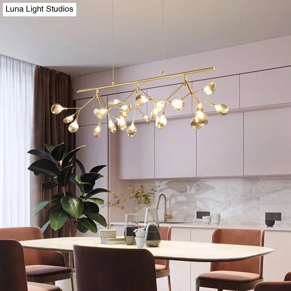 Gold-toned modern chandelier with branching arms and clear globe shades for dining featuring smoke grey glass firefly design