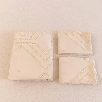 Cream-colored embroidered napkins with zigzag stitching complement the DecorBites™ soft tufted microfiber duvet cover set