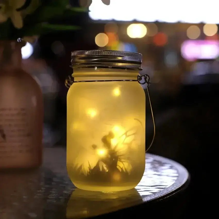 Decorbites™ solar mason jar with translucent yellow glass and metallic lid containing warm glowing fairy lights for garden decoration