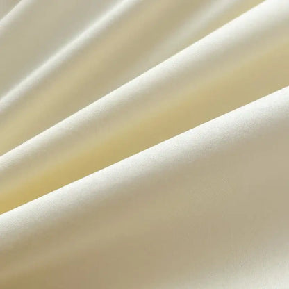 Soft cream-colored satin decorbites™ solid color brush fabric duvet cover with smooth reflective surface and gentle folds