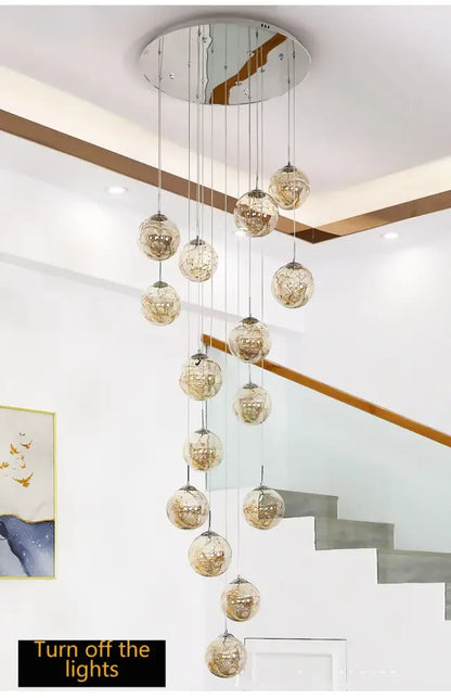 A modern chrome decorbites™ spiral crystal ball chandelier light with multiple spherical glass orbs suspended