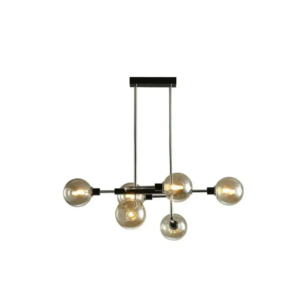 Modern black and chrome sputnik hanging island light with six amber glass globe bulbs for dining room decor