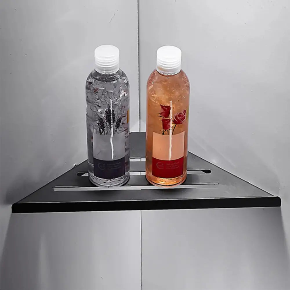 Two transparent plastic bottles with white caps on a decorbites stainless steel corner shower shelf for bathroom organization