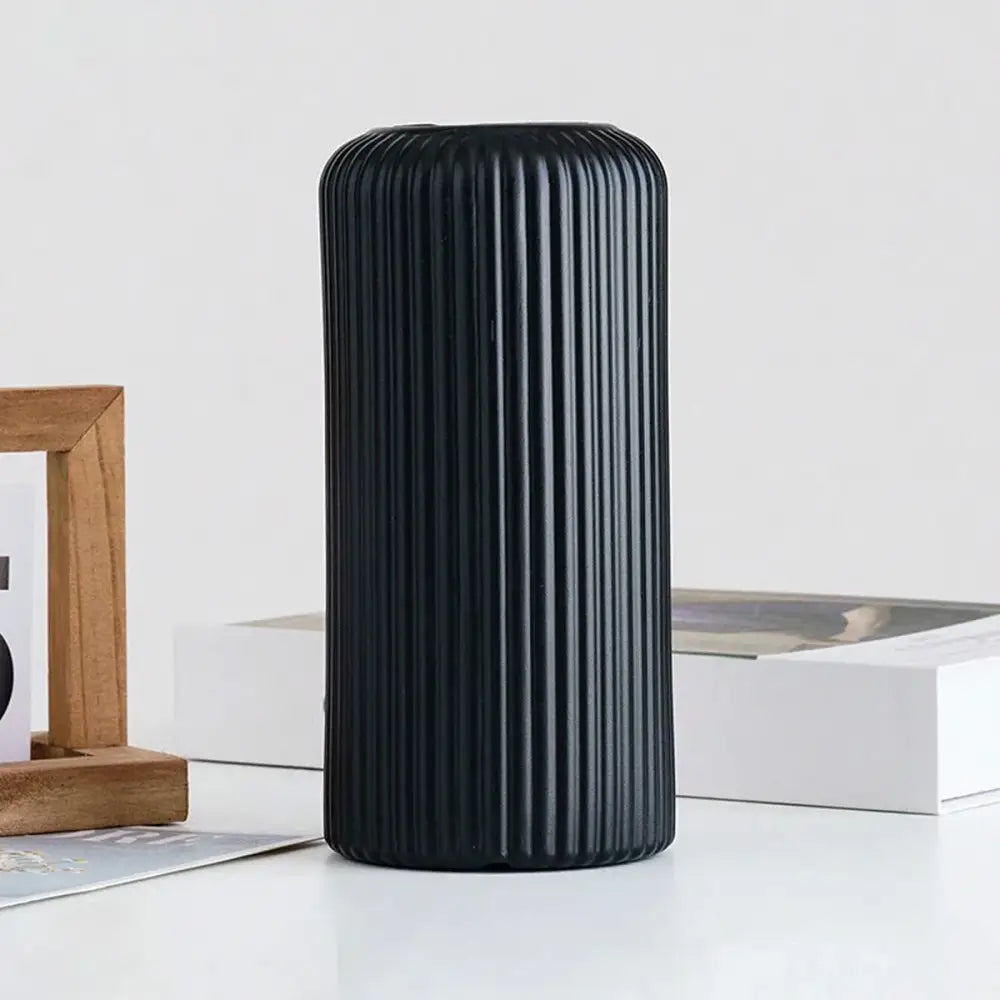 Black cylindrical striped ceramic-like plastic vase with vertical ribbed texture for flowers by DecorBites™