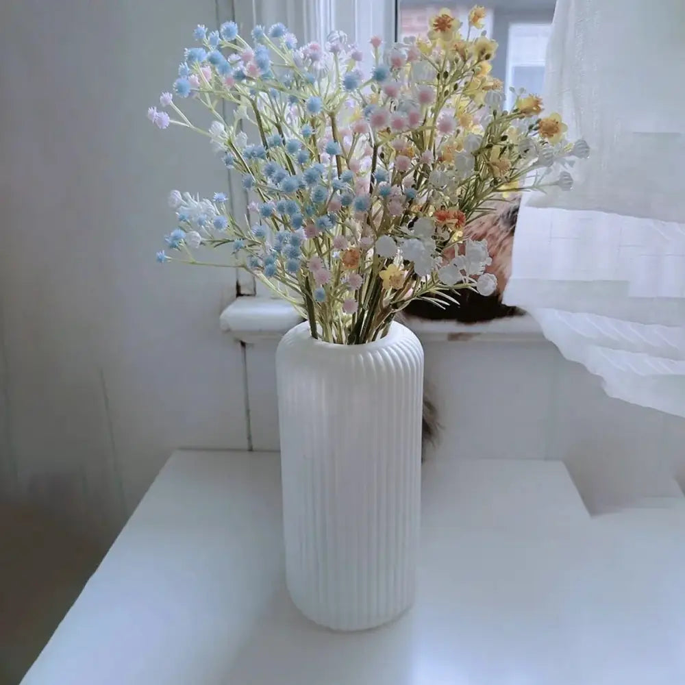 Decorbites™ striped ceramic-like plastic vase in white ribbed design holding pastel baby’s breath flowers