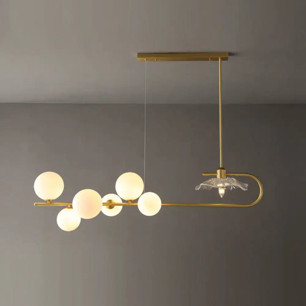 Gold-toned postmodern suspension lamp with lotus leaf design featuring frosted glass globes and crystal chandelier accent