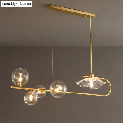 Gold-toned postmodern suspension lamp with lotus leaf design featuring clear glass globe bulbs and frosted glass shade