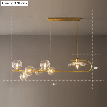 Gold-toned postmodern suspension lamp with clear glass globe bulbs and delicate lotus leaf design floral accent