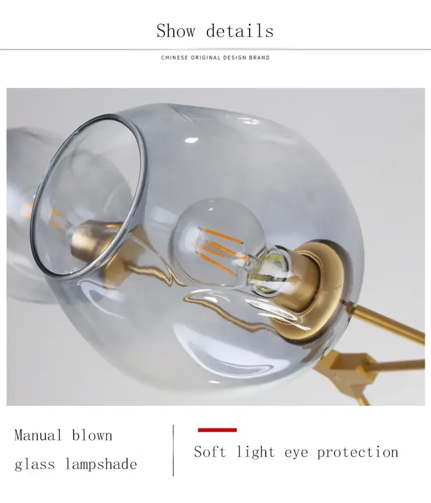 A translucent glass lampshade with gold-toned metal base and exposed filament bulb in a stylish nordic chandelier for living room and dining living room