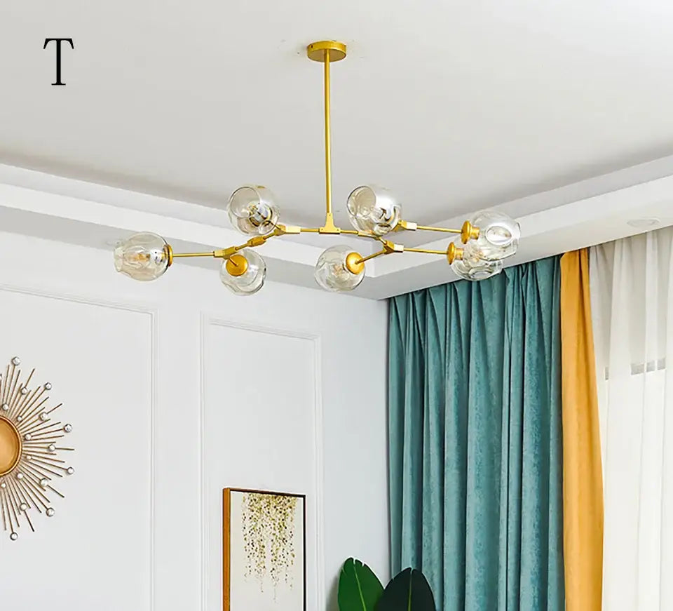 Gold-toned modern chandelier with clear glass globe bulbs styled as a stylish nordic chandelier for living room and dining