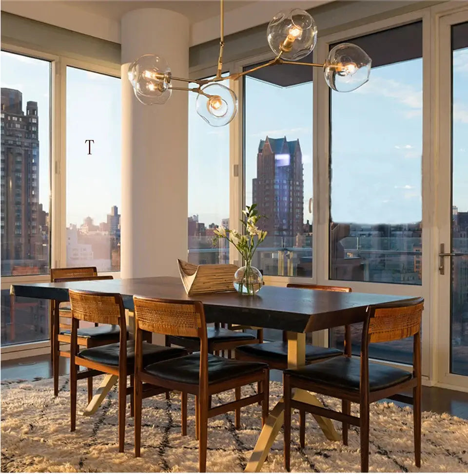Modern chandelier decorbites™ stylish nordic chandelier above a dining table with dark wood top and woven back chairs