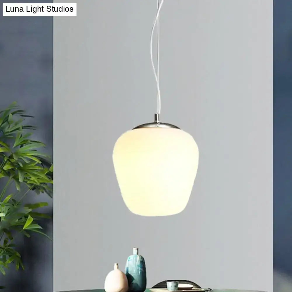 A sleek nordica pendant light with frosted opal glass and polished chrome fixture ideal for office and kitchen island