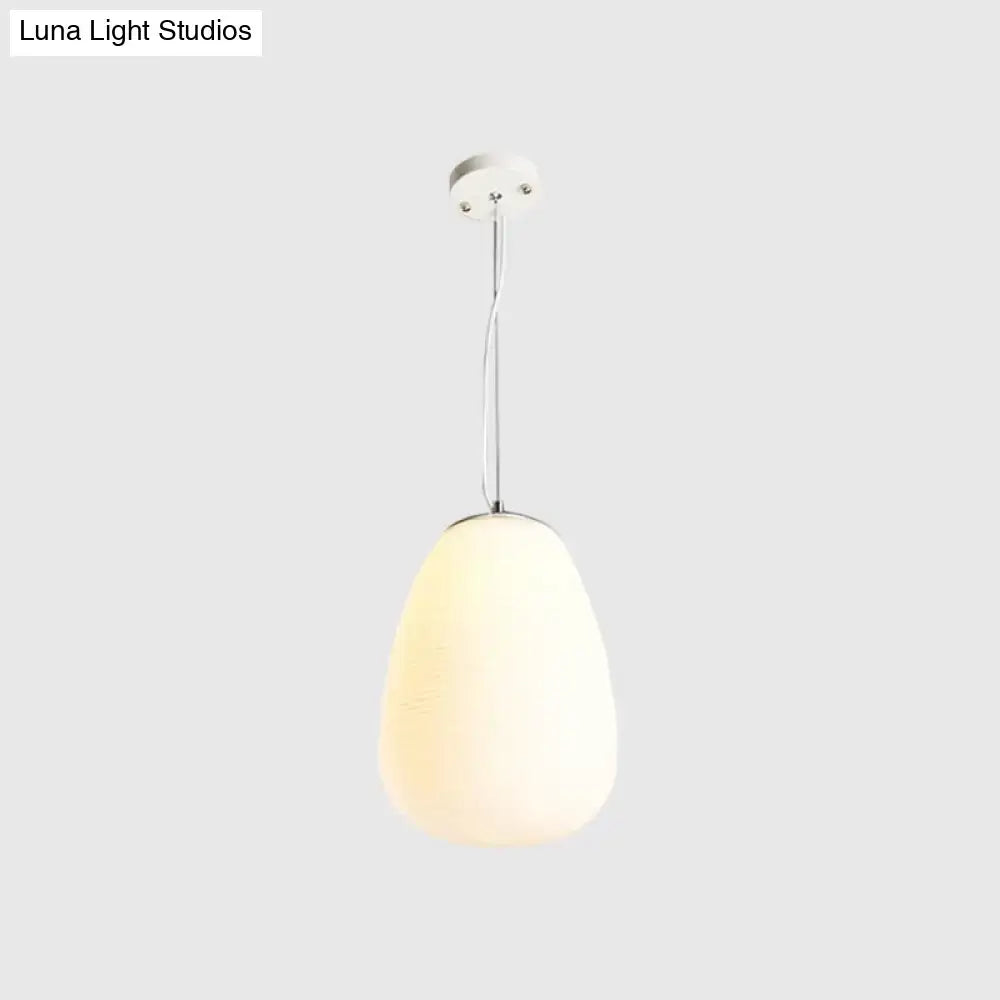 A sleek nordica pendant light with teardrop opal glass shade and polished chrome hardware ideal for office and kitchen island