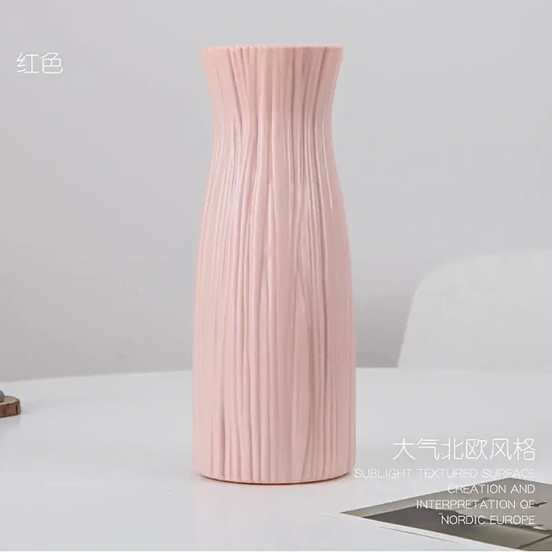 A blush pink DecorBites™ plastic flower vase with vertical ribbed texture and sleek modern design for home decor