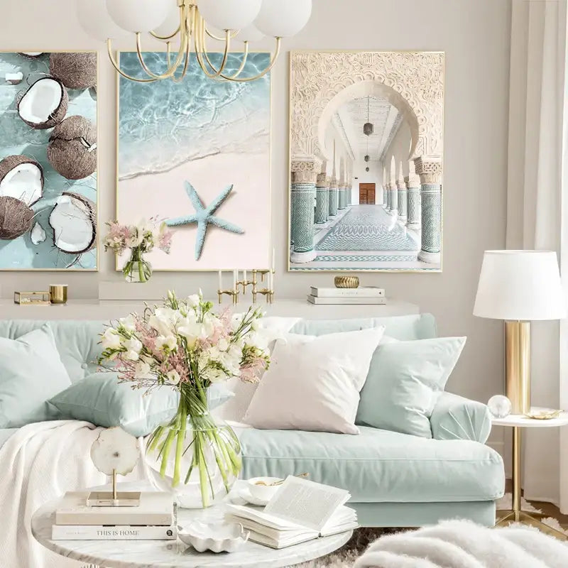 Light blue velvet sofa with white and pale pink pillows beside decorbites summer beach seashell canvas wall art