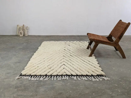 Cream-colored chunky knitted tapis beni ouarain with bold chevron pattern and black border trim by DecorBites™