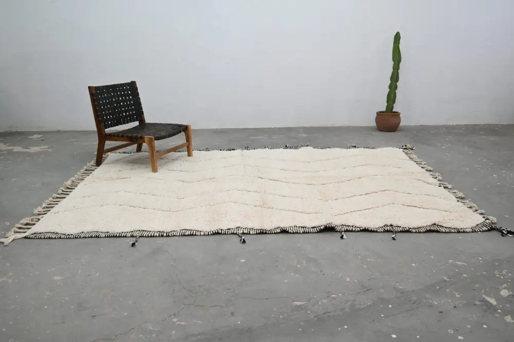 Cream-colored handwoven tapis beni ouarain rug with black zigzag patterns and tassels by decorbites 290 x 205 cm