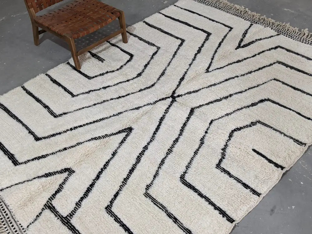 Cream-colored wool tapis beni ouarain rug with bold black geometric patterns and fringed edge 290 x 213 cm
