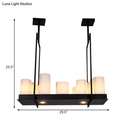 Black metal island pendant light with six frosted glass candle-style bulbs and two recessed lights in traditional barrel frosted design
