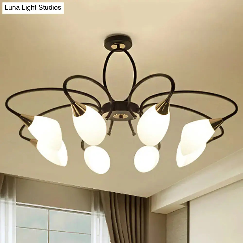 Black wrought iron chandelier with five frosted white glass shades and gold-toned accents for traditional oval white glass décor