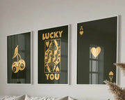 Three framed black and gold playing card wall art pieces featuring cherries queen with lucky you and ace of hearts trendy retro wall decor