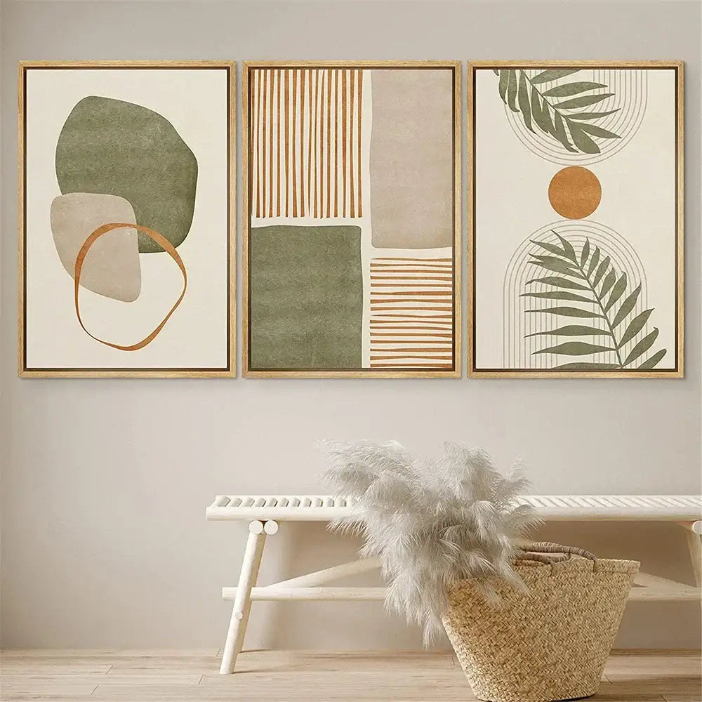 Three framed DecorBites tropical leaves canvas wall art pieces with earthy tones and abstract shapes in light wood frames