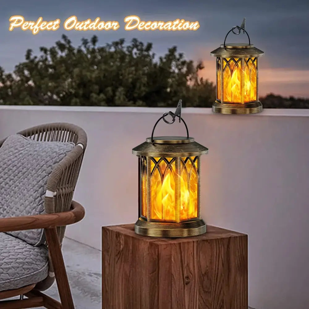 Brass-colored decorbites upgraded flickering flame solar lantern with glowing orange flame and arched glass panels