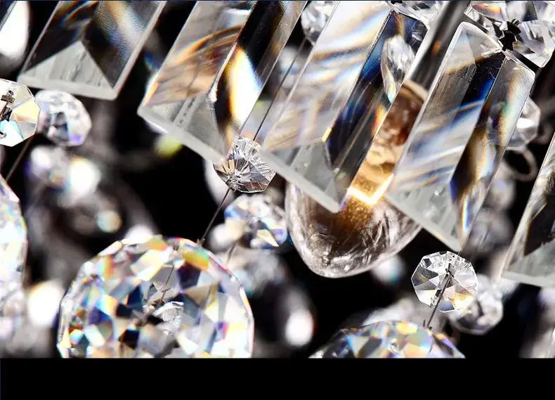 Clear faceted crystal pendants hang from the decorbites modern crystal chandelier for dining room lighting
