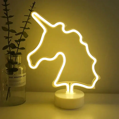 A glowing yellow led neon unicorn head lamp with minimalist design and white circular base for home decoration