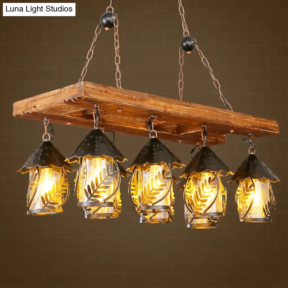 Rustic wooden beam chandelier with five black metal birdhouse shades featuring leaf etchings warm amber glass panels rectangle white fabric clear glass construction compatible with 220v-240v 110v-120v
