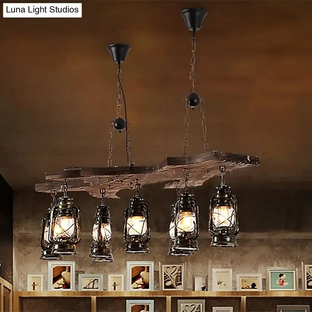 Decorbites vintage industrial linear chandelier with five black metal lanterns on a rustic wooden beam in antique brass