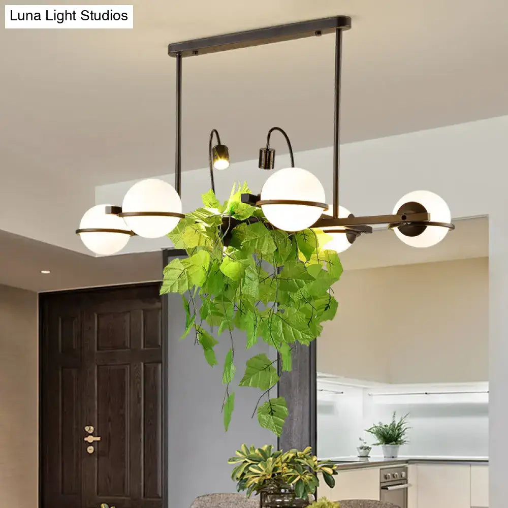 DecorBites™ vintage black metal island lighting fixture with five frosted glass globes and hanging green plant centerpiece